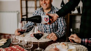 A person pouring wine into a glass at a table with plates of food and other glasses. - Agriturismo Cà del Nono (Moasca)