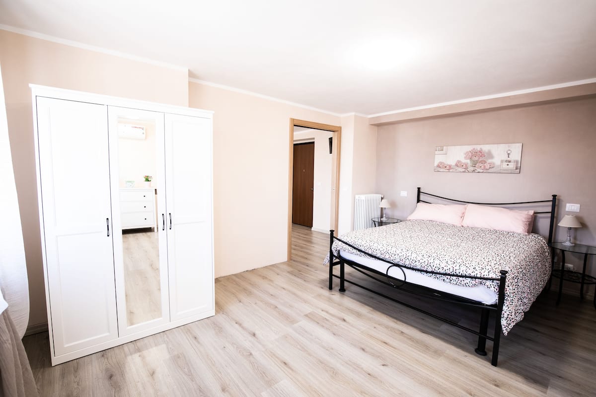 A bedroom with a bed, wardrobe, and a radiator.