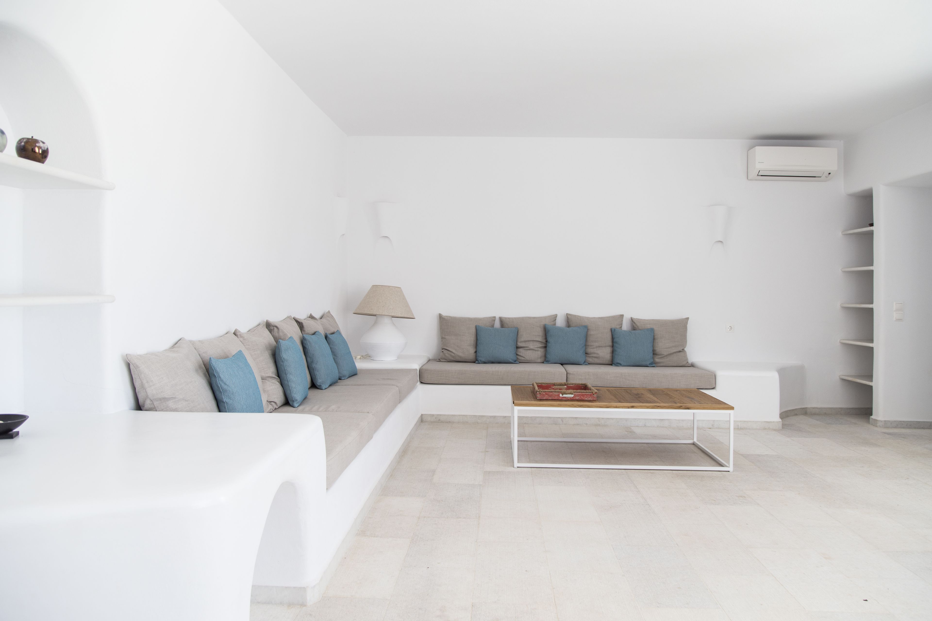 Ein modernes Wohnzimmer mit einem weißen Sofa, einem Couchtisch und einer Lampe.