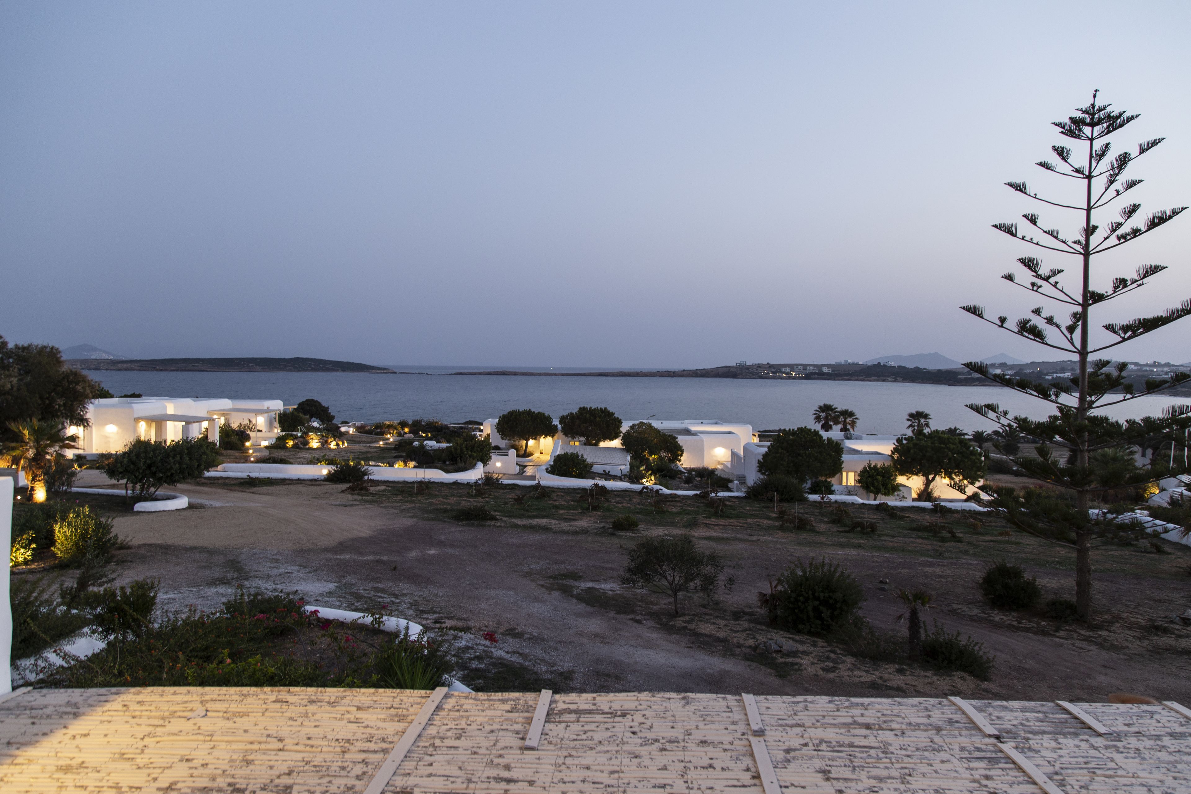 Un hôtel situé sur la côte, avec des bâtiments blancs, une plage de sable et une vue sur la mer.