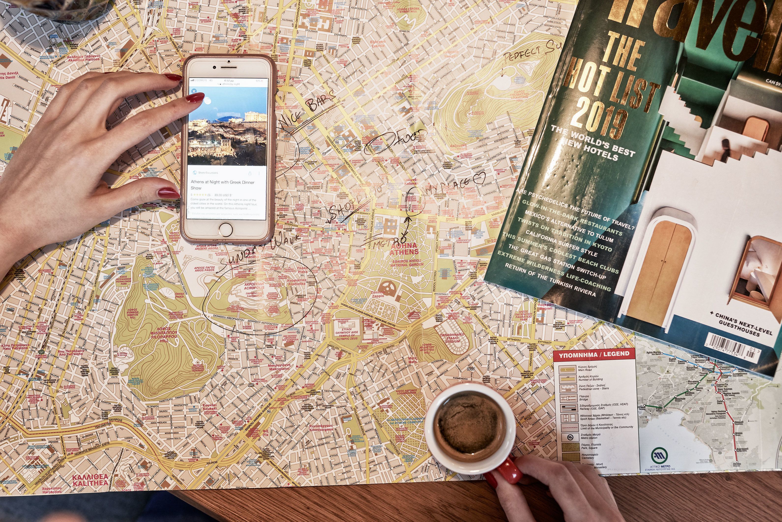 Een gedetailleerde kaart met notities, een smartphone die een webpagina toont, een reisgids en een koffiekop.