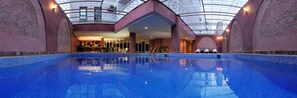 An indoor swimming pool with a glass ceiling, surrounded by walls with intricate designs. - Hotel Tghat (Fes)