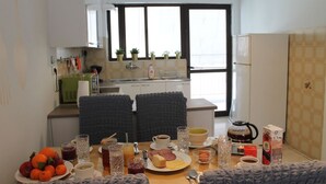 Eine kleine Küche mit Essbereich, ausgestattet mit einer Frühstücksecke und verschiedenen Speisen und Getränken.