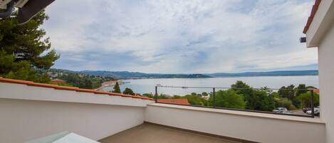 A balcony with a clear view of a lake and distant hills.