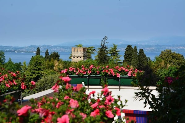 A view of a coastal area with a tower, lush greenery, and a body of water in the background.