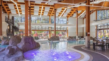 Ein Innenpool mit Whirlpool, Felsformationen und einer Treppe zu oberen Ebenen.