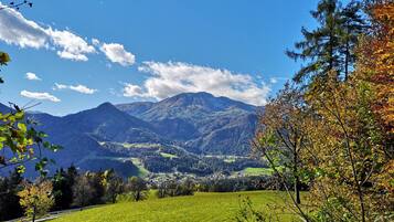 Un paisaje montañoso con un valle, un pueblo pequeño y un cielo despejado.