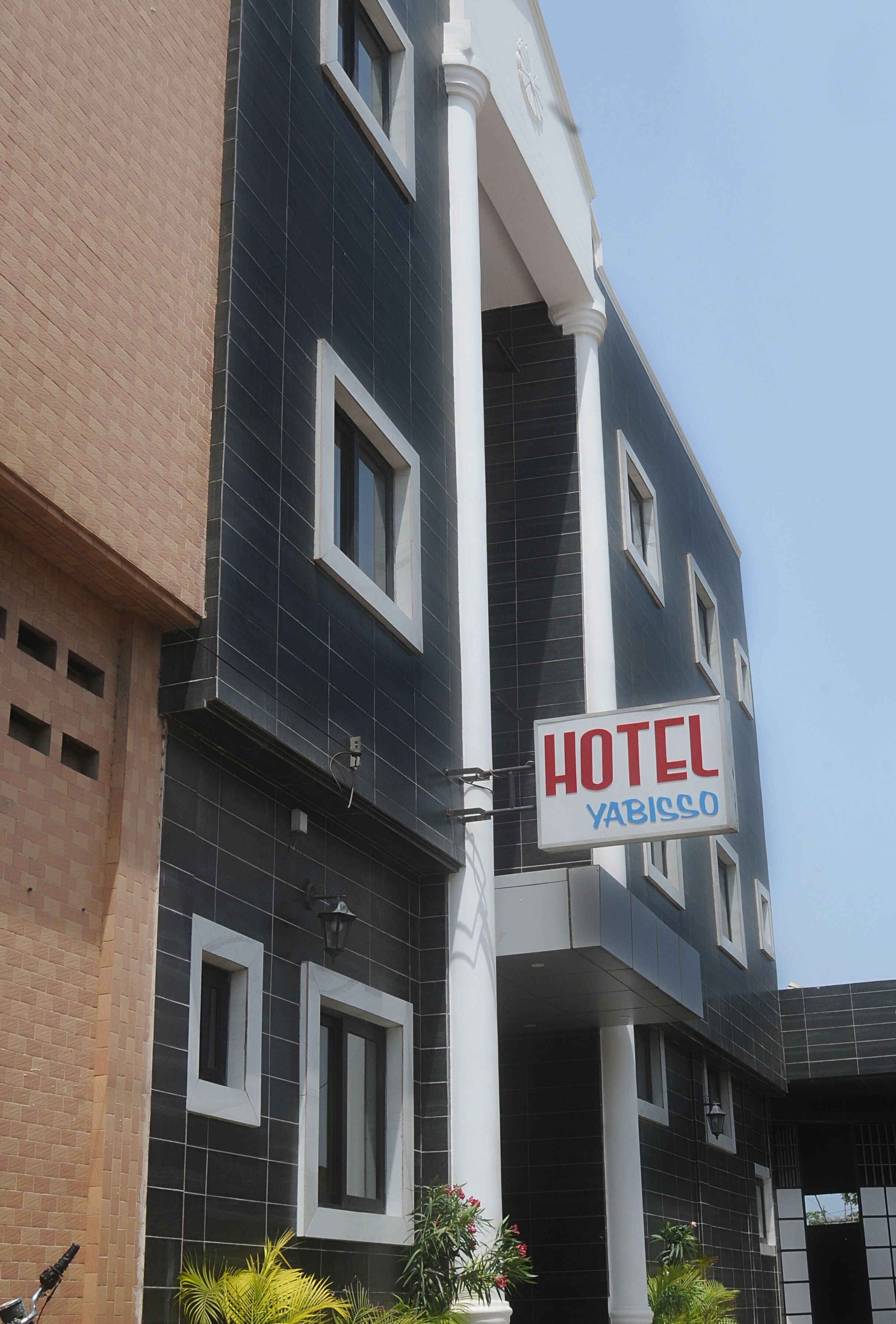 Ein Hotel namens "Yabisco" mit modernem Design, einem auffälligen Schild und einer Ziegelhausfassade.