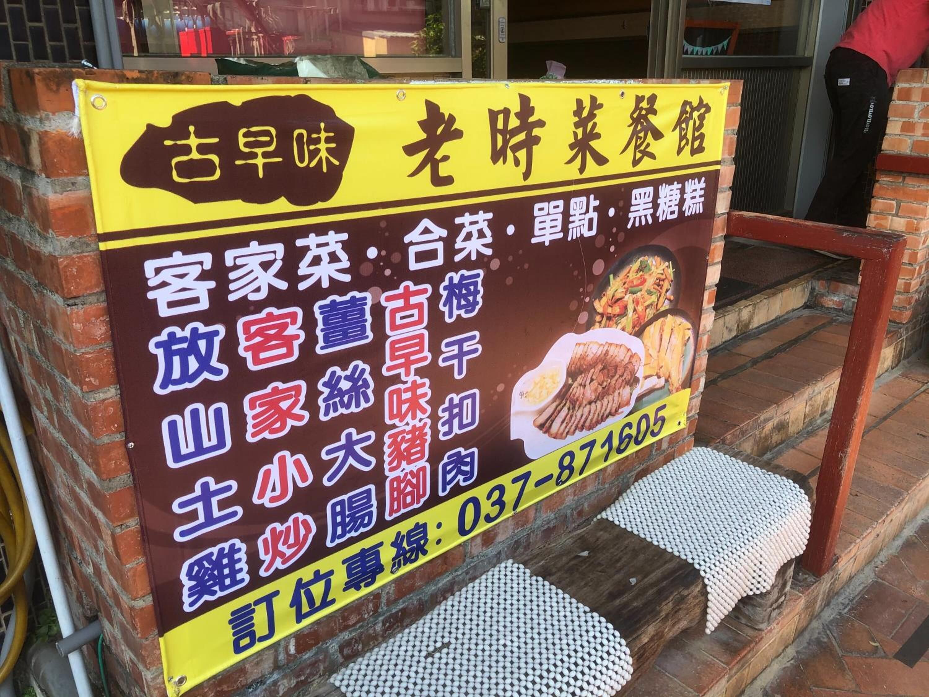 A restaurant signboard with Chinese characters and a phone number.