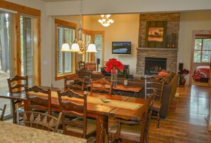 Enjoy meals with family and friends in this well-appointed dining area featuring a stone fireplace and large windows.