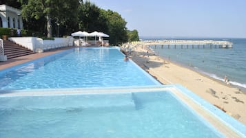 In Strandnähe, Liegestühle, Sonnenschirme, Strandtücher