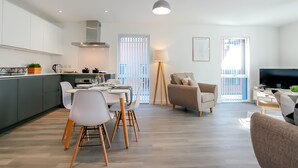 A modern apartment with a kitchen, dining area, and living room. - Hilltop Serviced Apartments - Northern Quarter (Manchester)