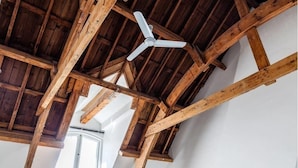 A room with exposed wooden beams, a ceiling fan, and a skylight. - Kerkstraat Residence (Amsterdam)