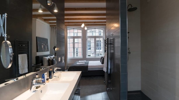 A modern bathroom with two sinks, a large mirror, and a shower. - Kerkstraat Residence (Amsterdam)