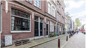 A row of traditional brick buildings with large windows and a cobblestone street. - Kerkstraat Residence (Amsterdam)