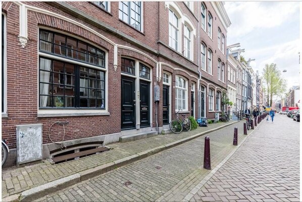 A row of traditional brick buildings with large windows and a cobblestone street. - Kerkstraat Residence (Amsterdam)