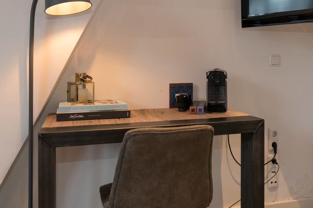 Un espacio de trabajo moderno con escritorio, silla y televisor montado.