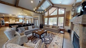 A spacious living room with a large window, a fireplace, and a dining area. - Forest View Lodge with Access to Forest House (Bend)