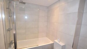A modern bathroom with a glass-enclosed shower, a white bathtub, and a toilet. - 2 Bedroom Luxury Apartment in Leicester (Leicester)