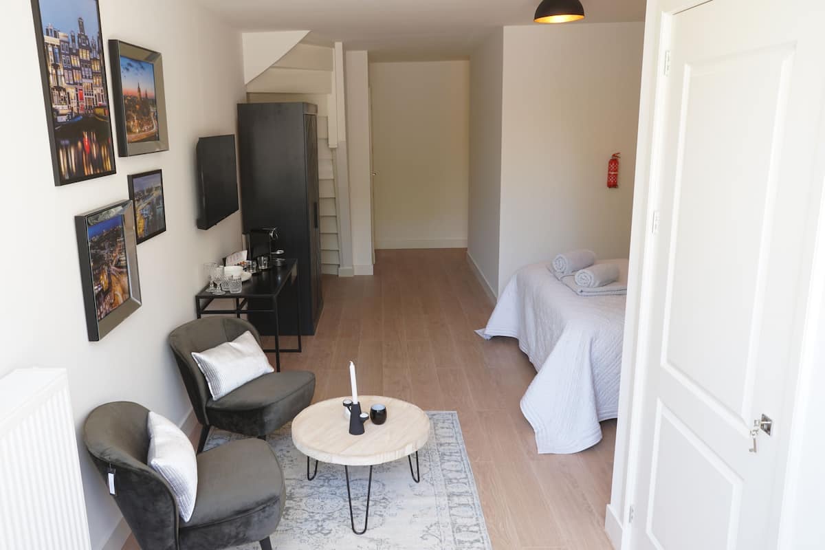 Un espacio habitable compacto con una cama, una zona de estar con una mesa de centro y una kitchenette.