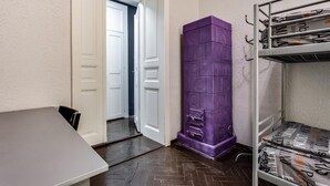A room with a bunk bed, a purple storage unit, a white door, and a grey table. - Mister Econom Hotel - Hostel (Lviv)