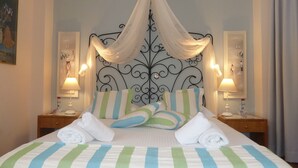 A neatly made bed with striped bedding, a canopy, and two bedside lamps. - Calergi 15: Boutique Resort 1BDR/1LVR Apt- Pool/Rooftop/Nature/Sunset/Rethymno (Ατσιπόπουλο)