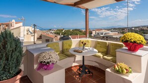A rooftop terrace with a seating area, a table, and potted plants. - Calergi 15: Boutique Resort 1BDR/1LVR Apt- Pool/Rooftop/Nature/Sunset/Rethymno (Ατσιπόπουλο)