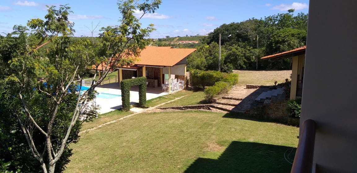 A residential property with a swimming pool, a covered patio, and a view of the surrounding landscape.