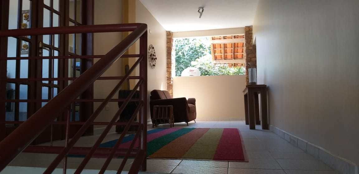 Una escalera conduce a una habitación con una ventana, una alfombra colorida y una silla de madera.
