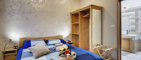 A bedroom with a bed, bedside table, and a wooden wardrobe.