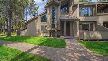 A modern two-story house with a paved driveway and a well-maintained lawn.
