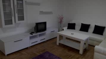 Departamento Confort, vista al jardín | Área de sala de estar | Televisión de pantalla plana