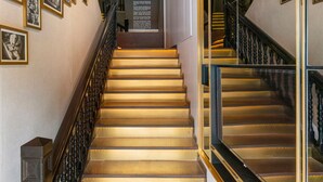 A staircase with a handrail, surrounded by framed pictures on the walls. - ST Signature Chinatown (Singapore)