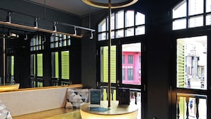 A modern lobby with a marble floor, a round light fixture, and large windows offering views of the city. - ST Signature Chinatown (Singapore)