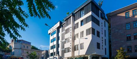 A modern hotel with a prominent 'Palace Hotel' sign, multiple floors, and a glass entrance.