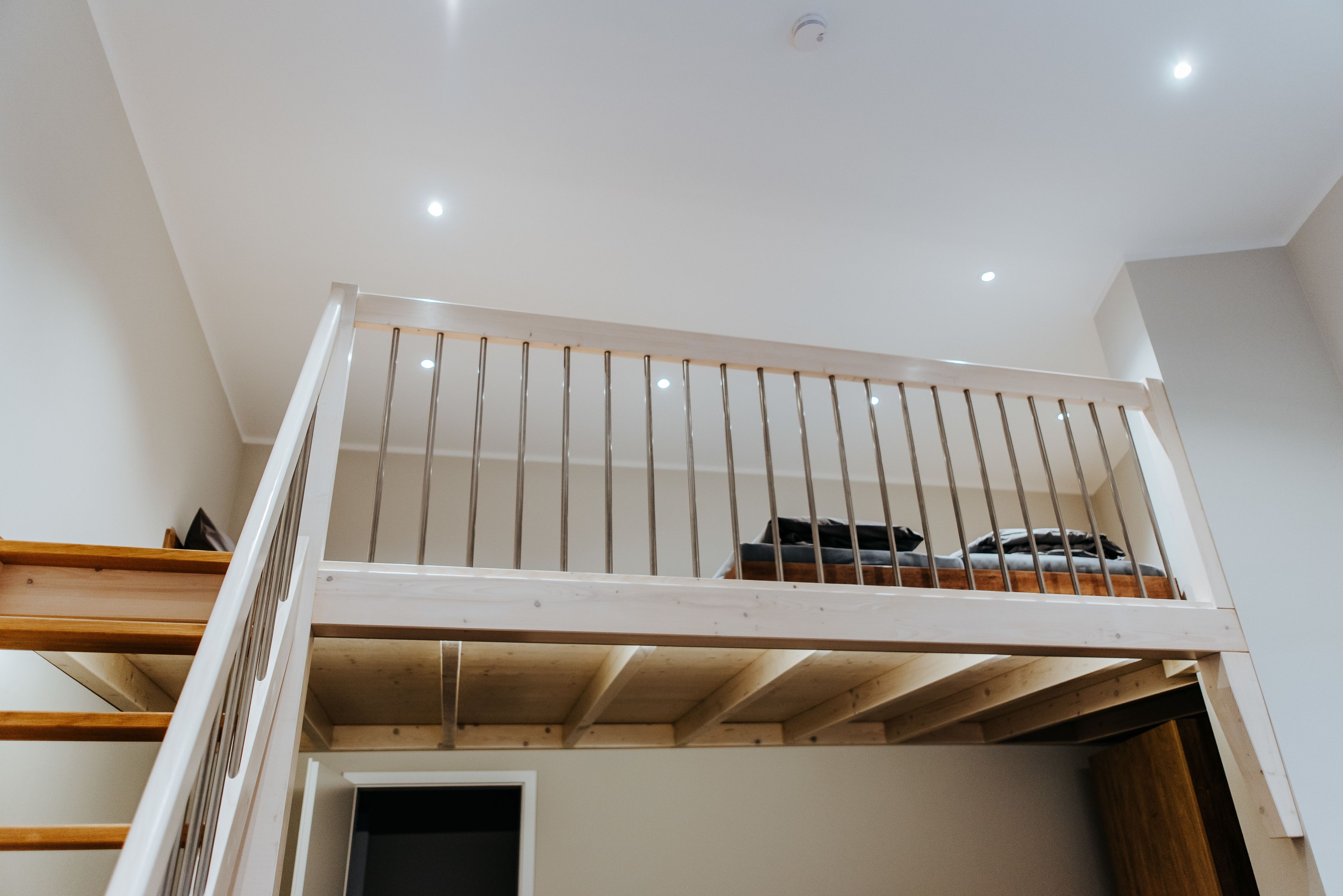 Un dormitorio estilo loft con techo de madera y diseño de techo inclinado.