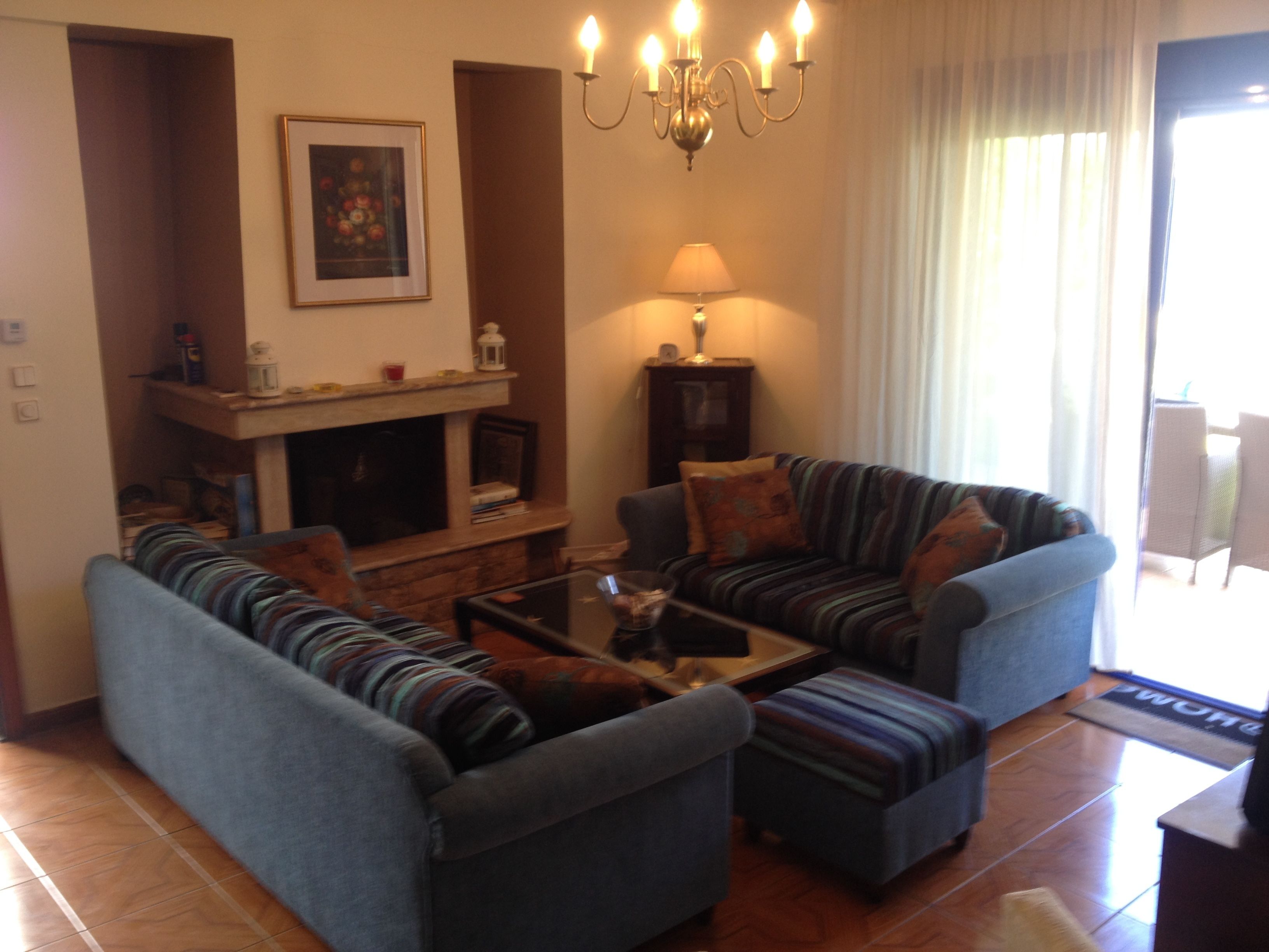 A living room with a fireplace, a sofa set, a coffee table, and a lamp.