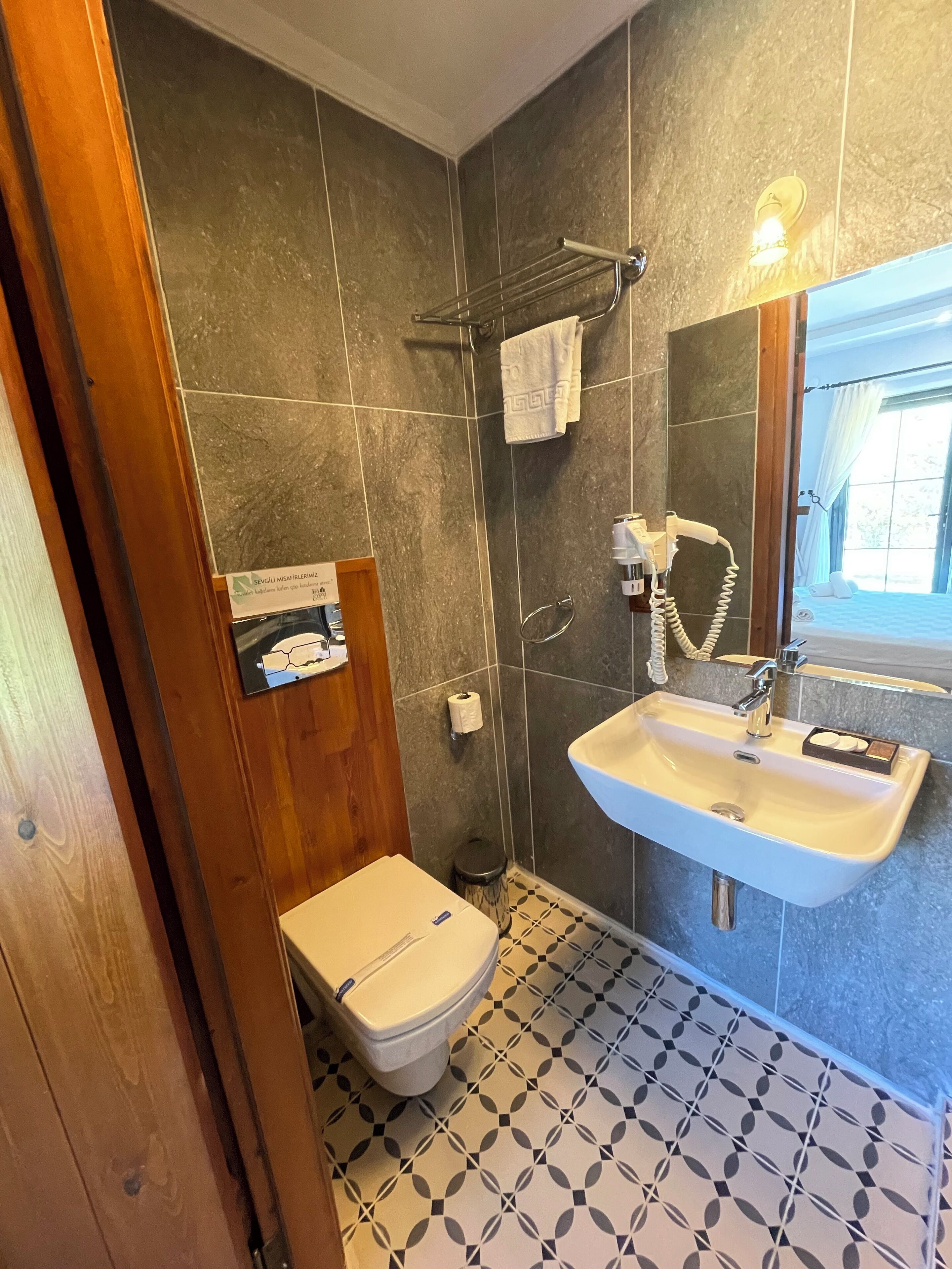 Une salle de bain avec des toilettes, un lavabo et une douche.