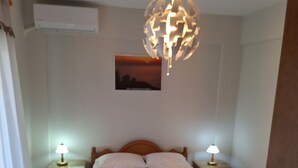 Ein Schlafzimmer mit einem hölzernen Bett, zwei Nachttischen mit Lampen, einem Wandbild und einer Deckenleuchte.