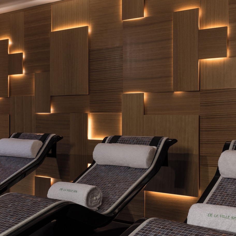 A spa room with massage chairs and wooden wall panels.