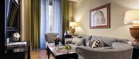 A well-lit living room with a sofa, armchair, and a coffee table with decorative items.