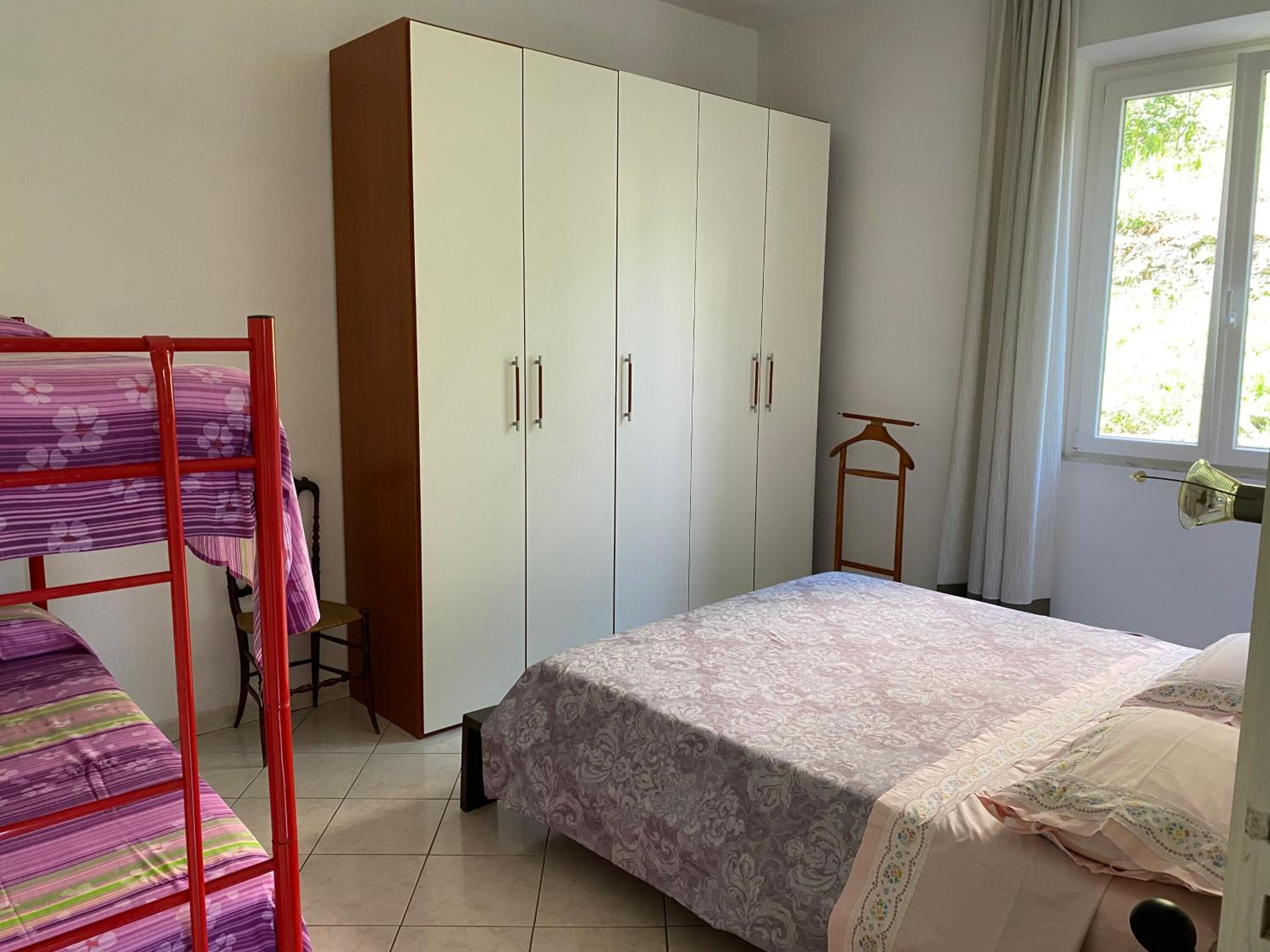 Una camera da letto con letti a castello, un armadio e una finestra con tende.