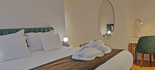 A hotel room with a bed, a bedside lamp, a mirror, and a chair. - Casa dos Ofícios Hotel (Tomar)