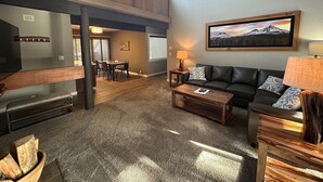 A spacious living room with a large TV, a fireplace, and a dining area. - Central Sunriver Stay with Access to The Cove (Sunriver)