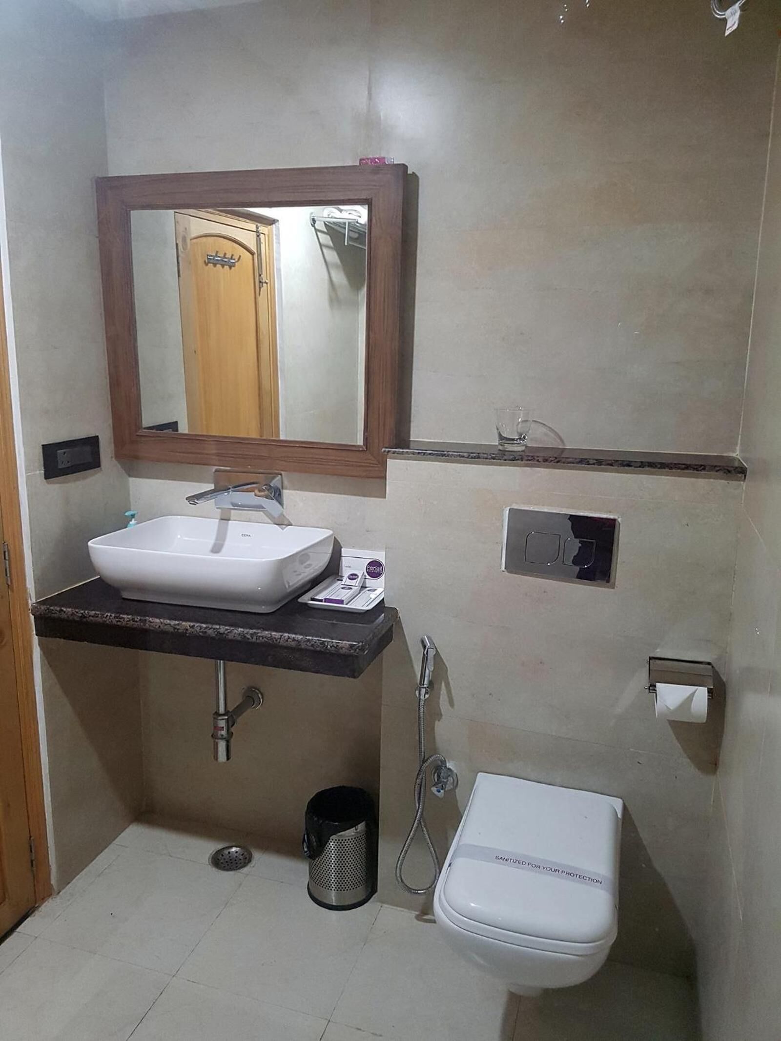 A small bathroom with a white sink, mirror, and toilet.