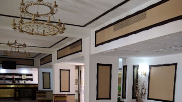 A spacious lobby with a marble floor, a chandelier, and traditional furniture. - Hotel Antar Bechar (Bechar)