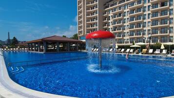 Una piscina cubierta, una piscina al aire libre, sombrillas, tumbonas