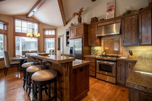 Enjoy cooking in this well-lit kitchen with a large island, stainless steel appliances, and granite countertop.