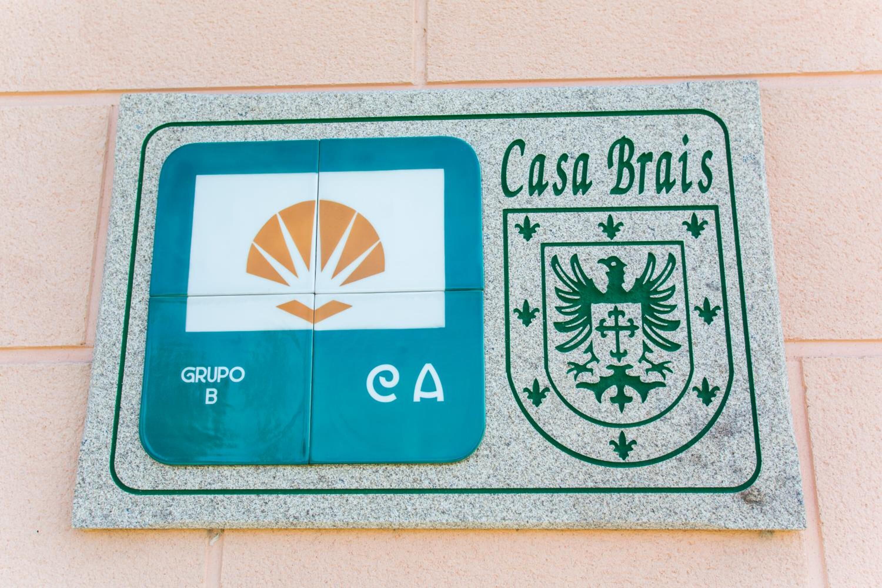 Una placa de piedra con un logotipo y texto, probablemente indicando un lugar o establecimiento.