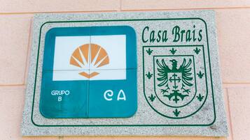 Una placa de piedra con un logotipo y texto, probablemente indicando un lugar o establecimiento.